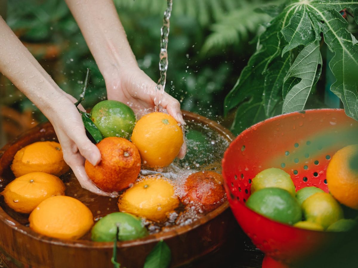 woman washing fresh fruits in tropical orchard